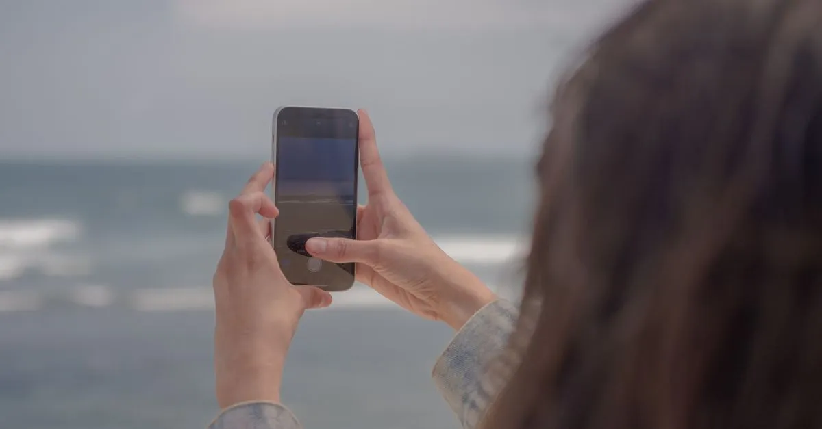 Person taking a travel photo on a smartphone that embeds GPS EXIF metadata