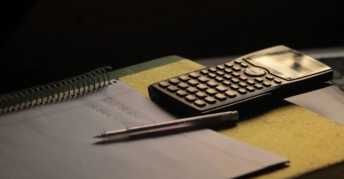 Math homework notebook with a calculator and pencil for working out fraction problems