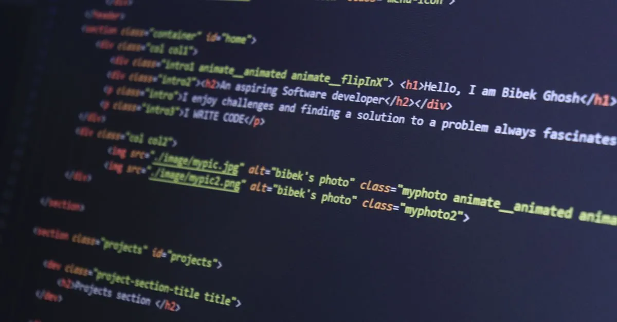 Web developer formatting HTML code in a code editor on a laptop screen