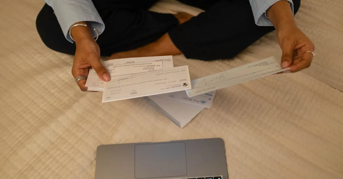 Hand writing an amount in words on a bank cheque with a pen