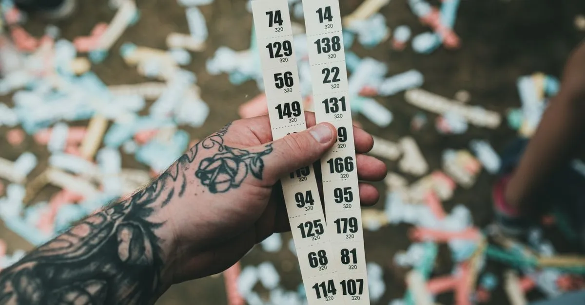 Hands drawing a winning raffle ticket from a pile during a prize draw