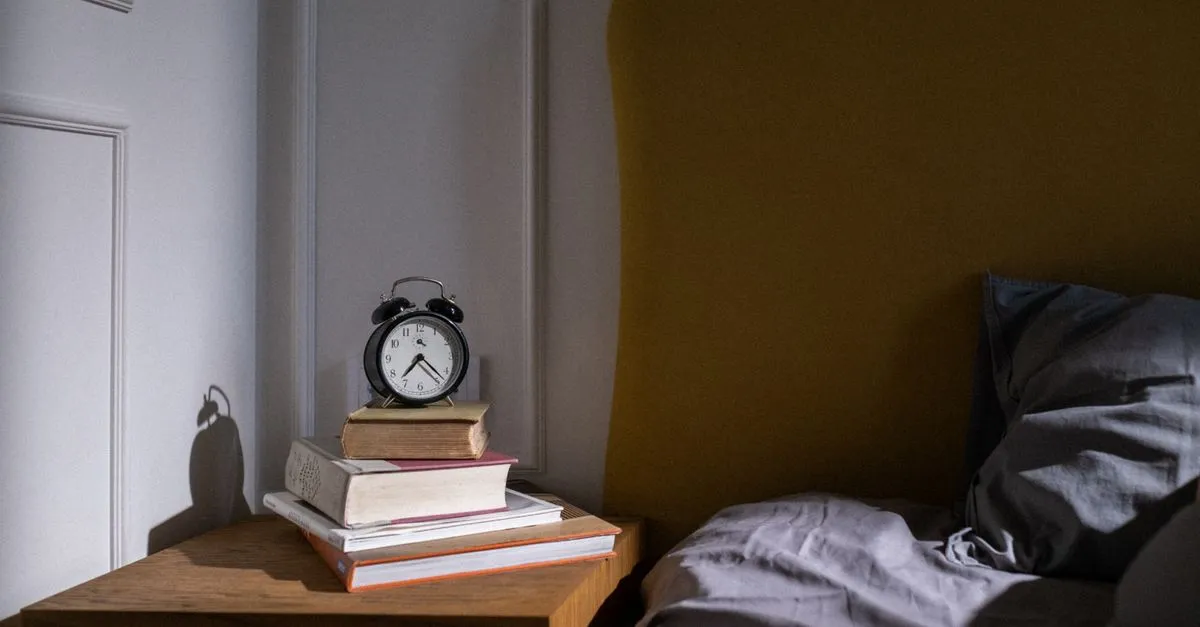 Alarm clock on a bedside table at night for planning bedtime with a sleep calculator