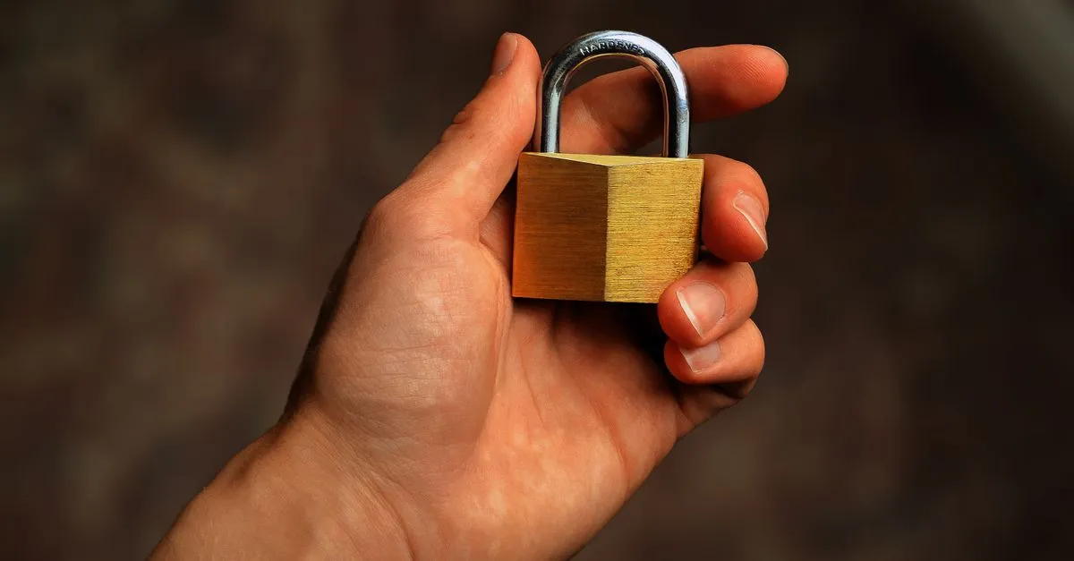 Padlock resting on a laptop keyboard, illustrating password-based text encryption in the browser